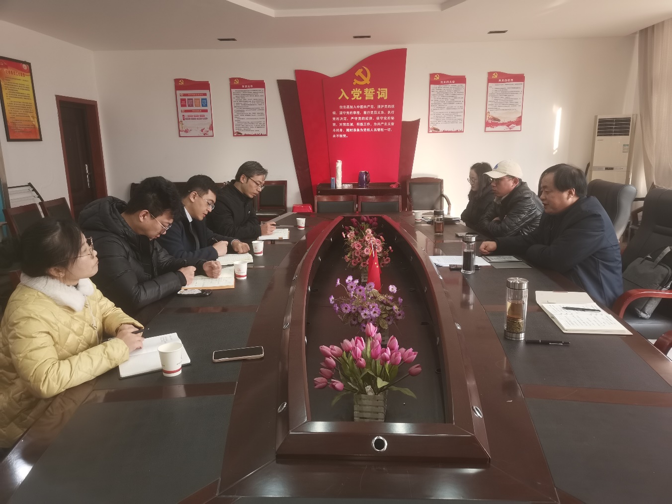 一群人坐在桌子前 中度可信度描述已自动生成